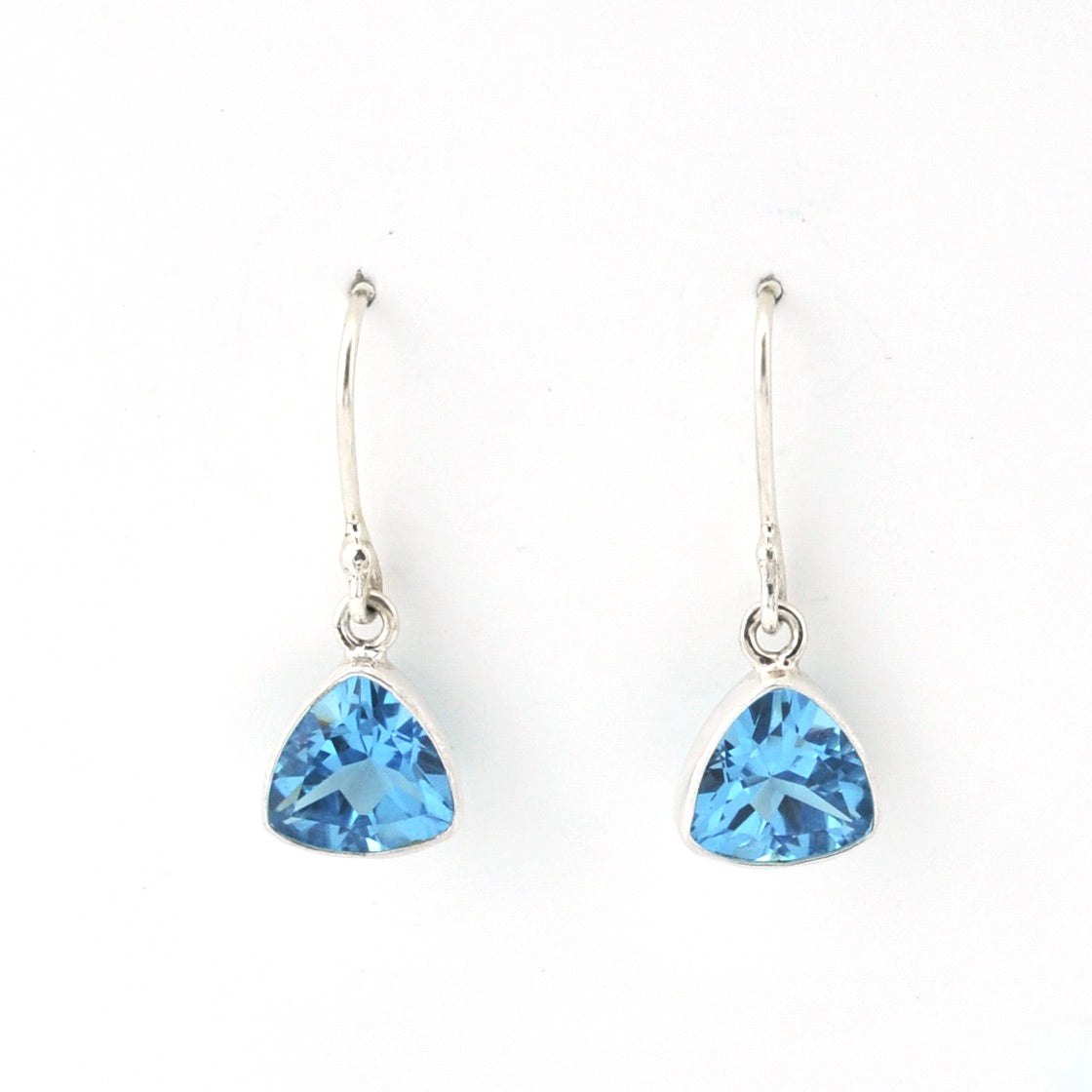 Pair of silver earrings with blue triangular gemstones on a white background