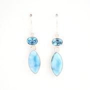 Pair of earrings with blue gemstones and light blue marquise-shaped stones on a white background