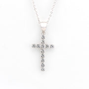 Silver cross pendant necklace with clear stones on a white background