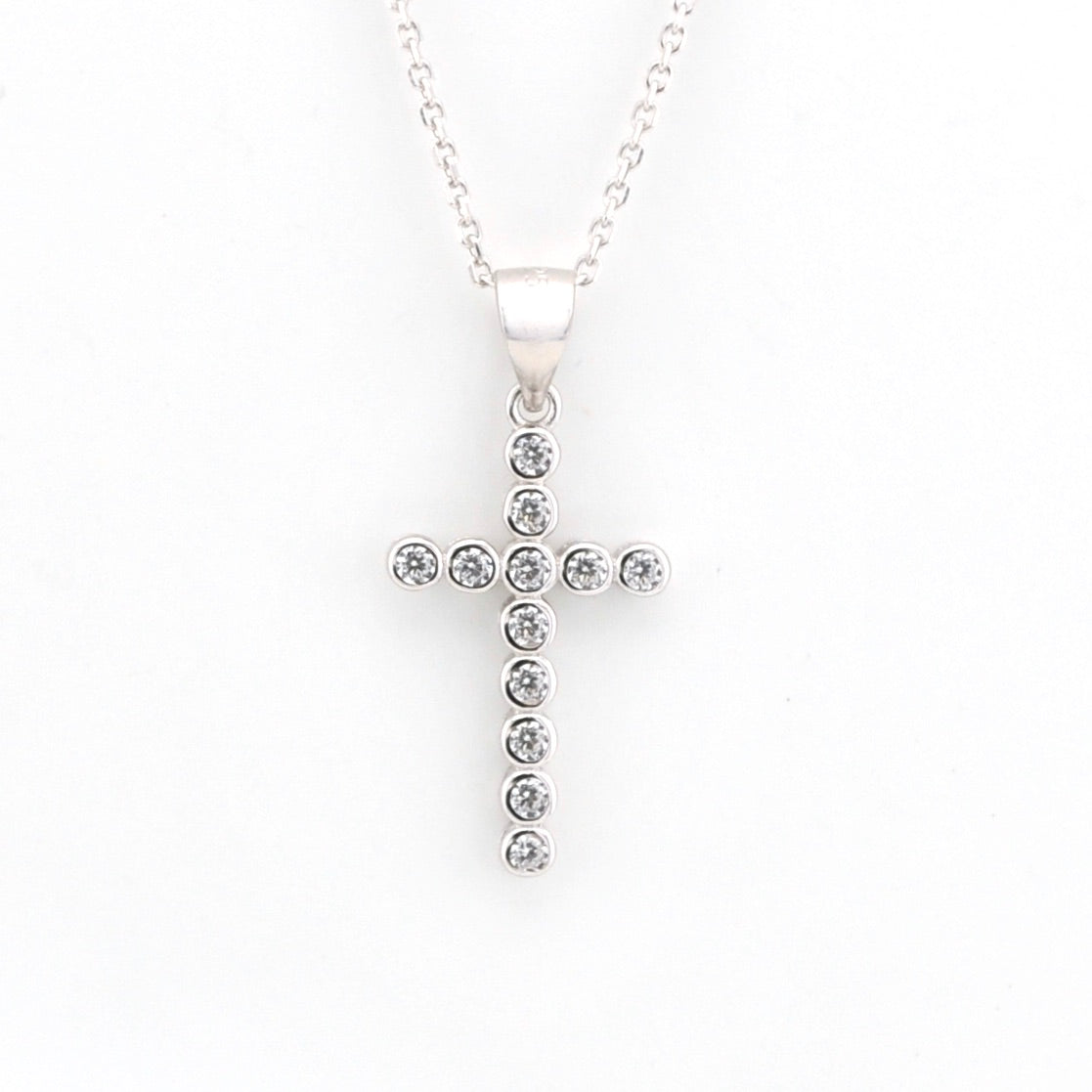 Silver cross pendant necklace with clear stones on a white background