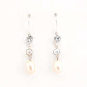 Pair of pearl and crystal drop earrings on a white background