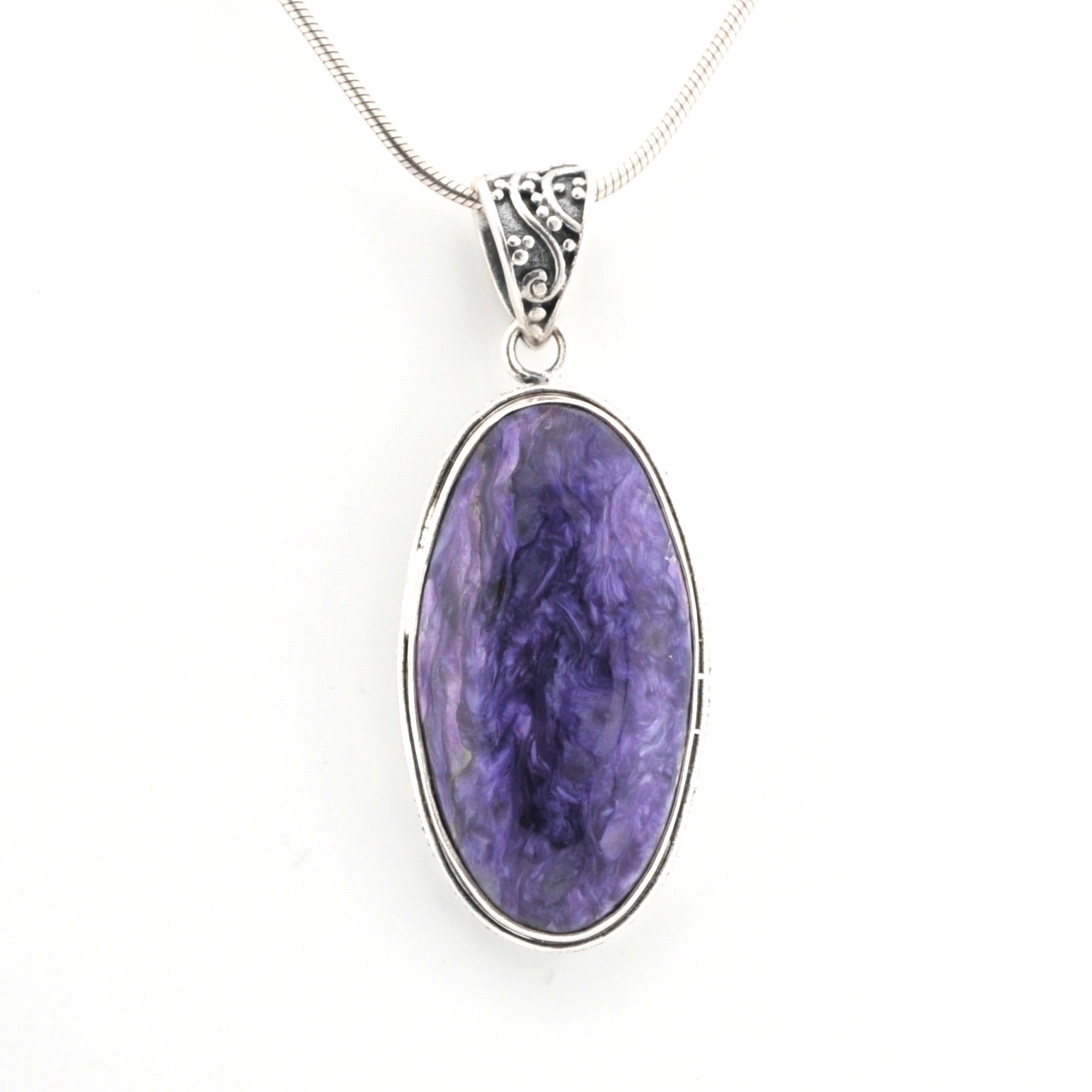 Purple stone pendant on a silver chain against a white background