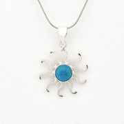 Silver sun-shaped pendant with a blue center on a white background