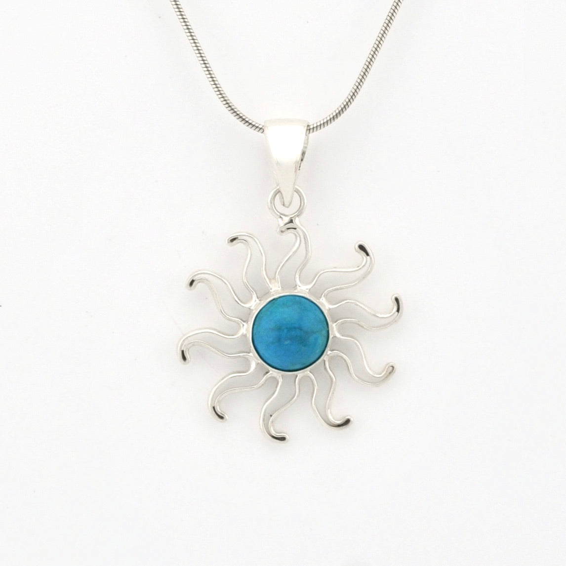 Silver sun-shaped pendant with a blue center on a white background