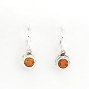 Pair of silver earrings with amber-colored gemstones on a white background