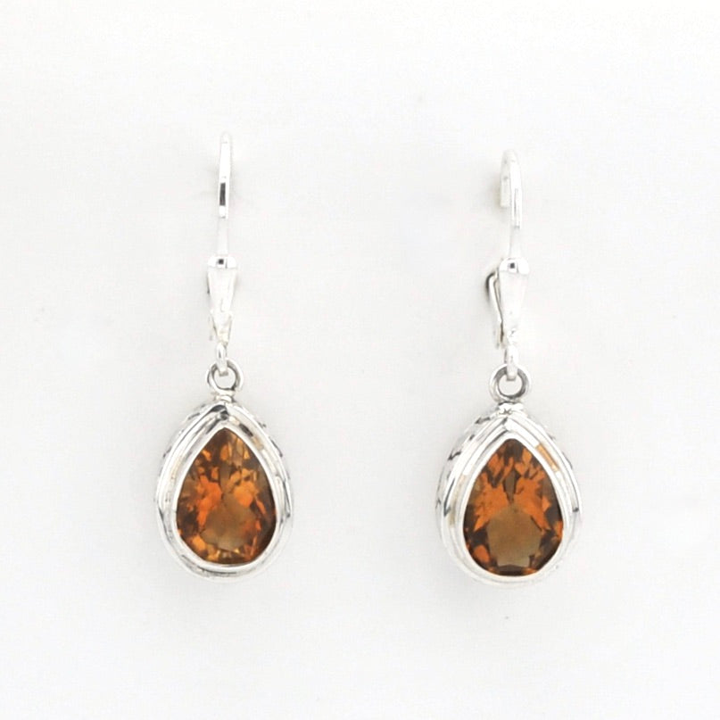 A pair of silver leverback drop earrings featuring teardrop-shaped orange gemstones in a silver bezel setting, shown against a plain white background.