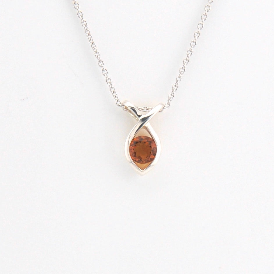 Silver necklace with a marquise-shaped pendant on a white background