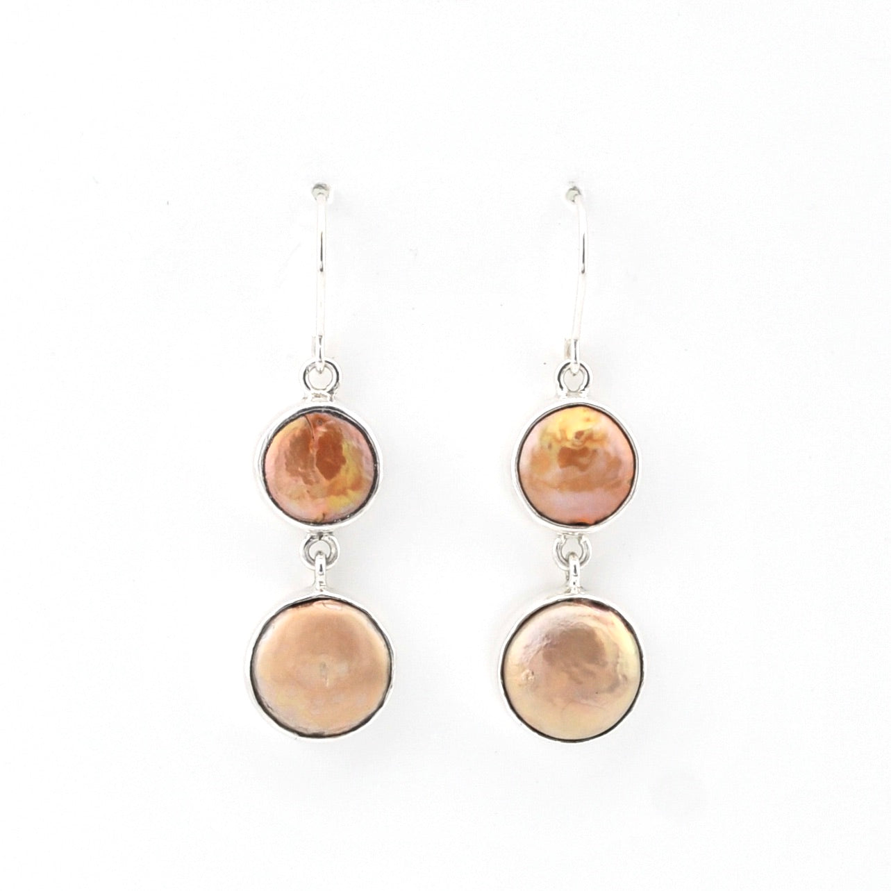 Pair of earrings with round beige stones on a white background