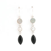 Pair of earrings with black and pearl-like stones on a white background