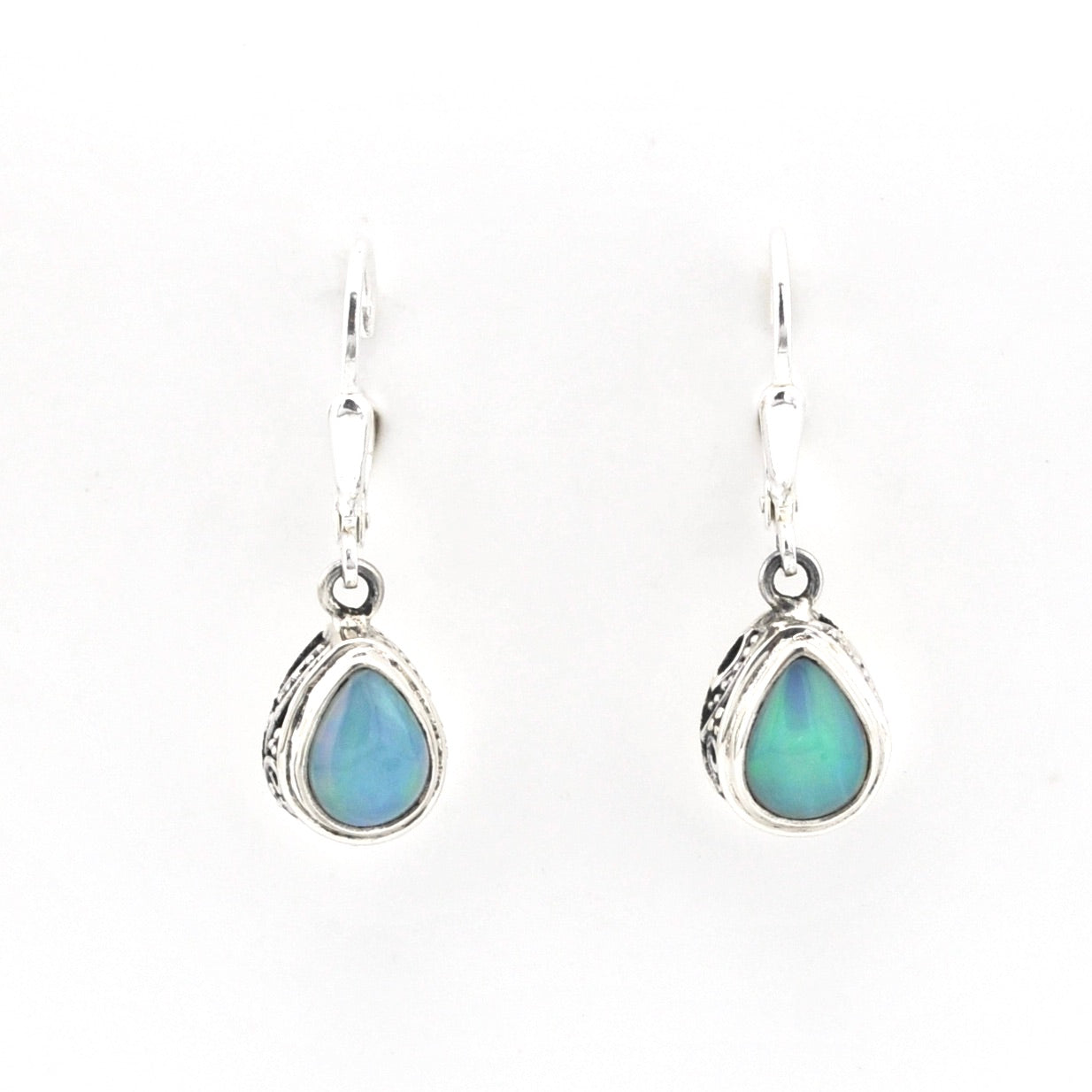Teardrop-shaped earrings with blue gemstones in silver settings on a white background