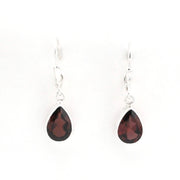 A pair of silver leverback drop earrings featuring faceted teardrop-shaped dark red garnet gemstones, shown against a plain white background.