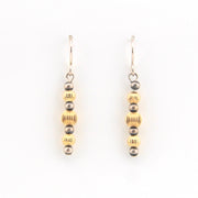 Pair of earrings with alternating gold and silver beads on a white background