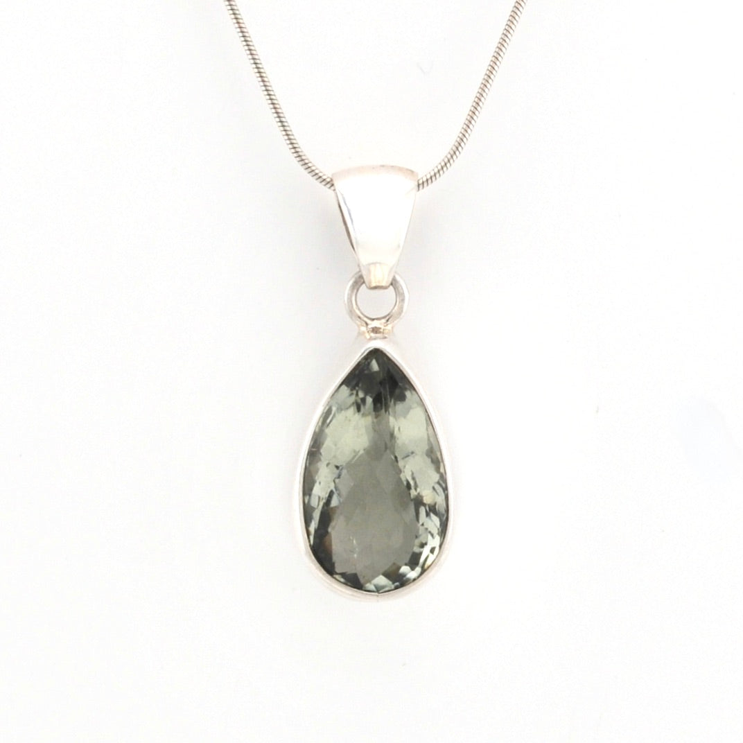 Teardrop-shaped green gemstone pendant on a silver chain against a white background