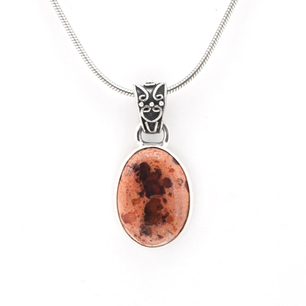 Necklace with an oval pendant featuring a brown and black pattern on a white background