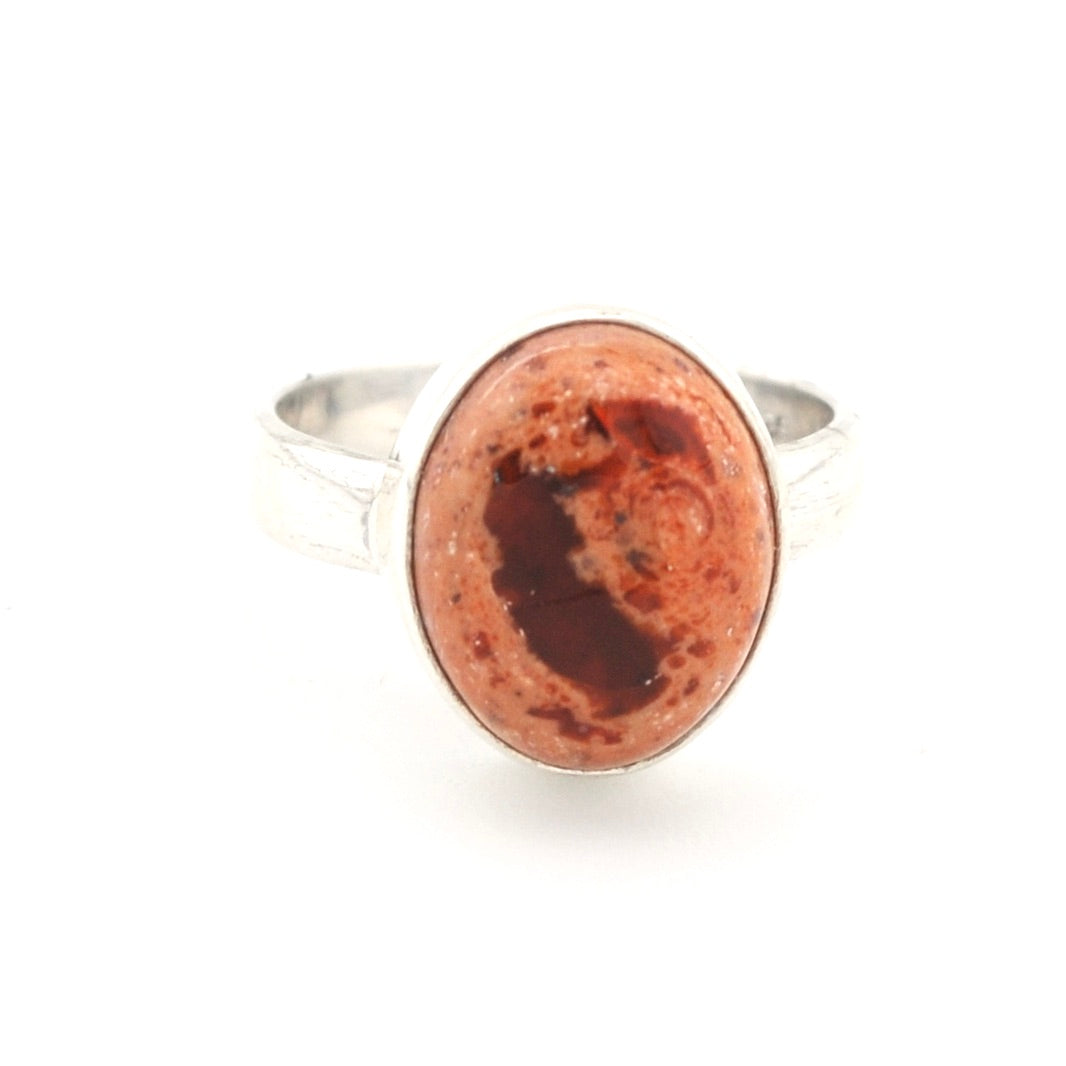 Silver ring with a large red stone on a white background