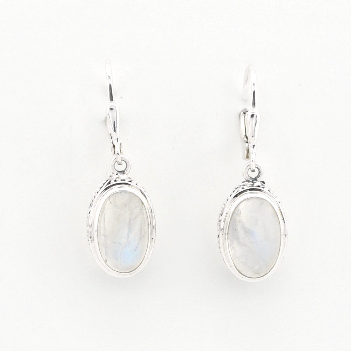 Pair of silver earrings with moonstone stones on a white background