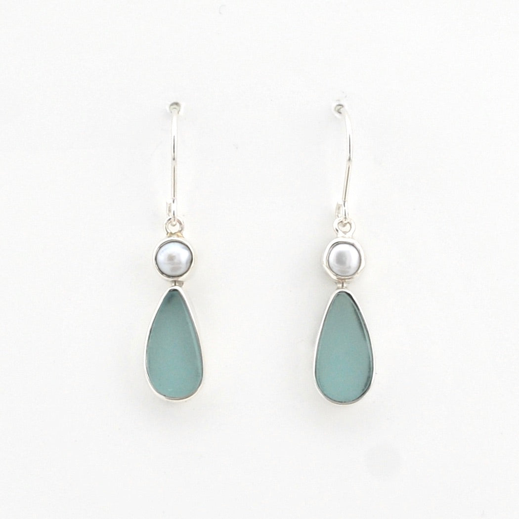 Teardrop-shaped earrings with light blue stones and pearl-like tops on a white background