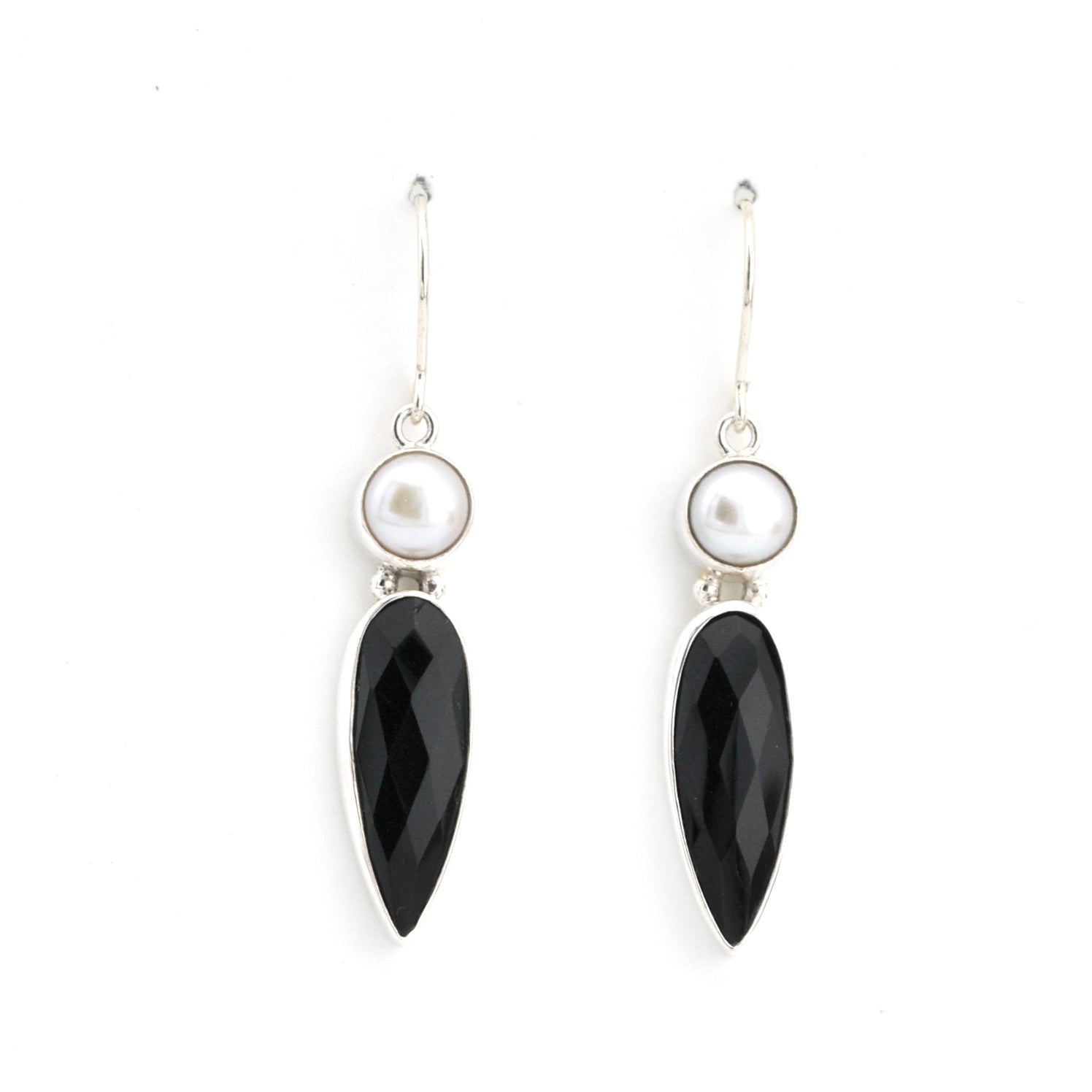 Pair of earrings with black teardrop-shaped stones and pearl-like centers on a white background