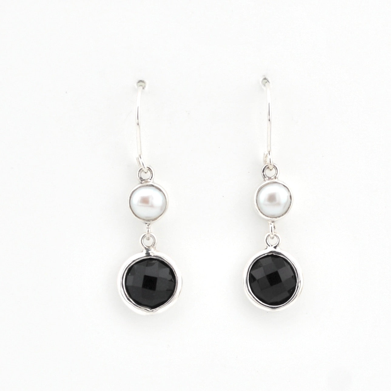 Pair of earrings with black stones and pearls on a white background