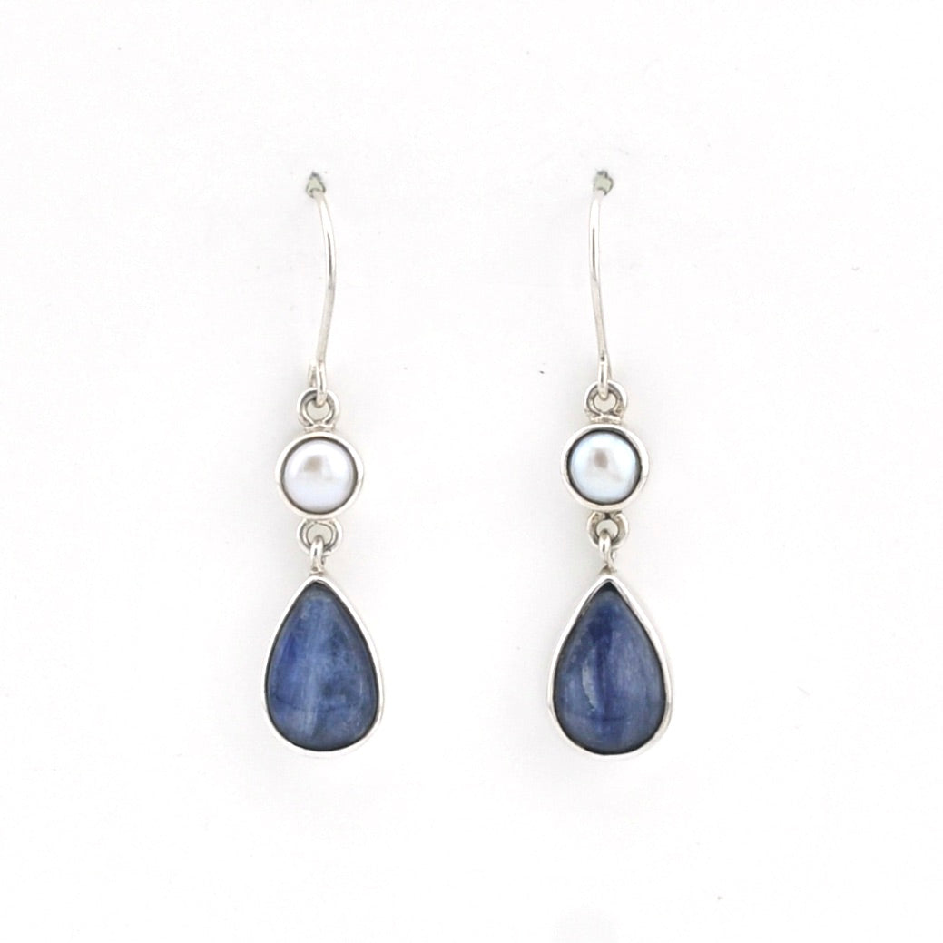 Pair of earrings with blue teardrop stones and white pearls on a white background