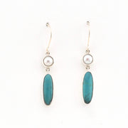 Pair of earrings with blue oval stones and pearl-like tops on a white background