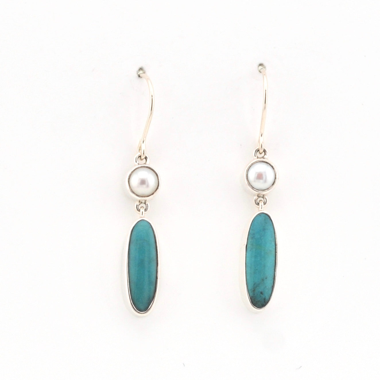 Pair of earrings with blue oval stones and pearl-like tops on a white background