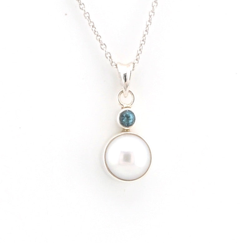 Necklace with a pearl pendant and blue gemstone on a white background