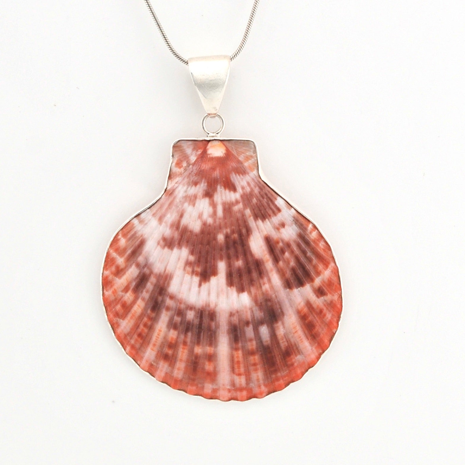 Red shell pendant with silver on a white background