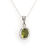 Silver pendant with a green gemstone on a white background