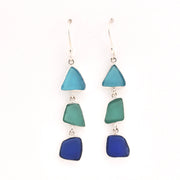 Pair of earrings with blue and green triangular glass on a white background