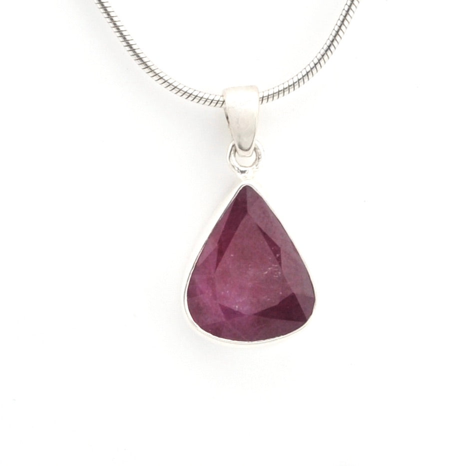 Teardrop-shaped purple gemstone pendant on a silver chain against a white background