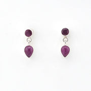 Pair of earrings with purple teardrop-shaped gemstones on a white background