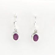 Pair of silver earrings with purple gemstones on a white background