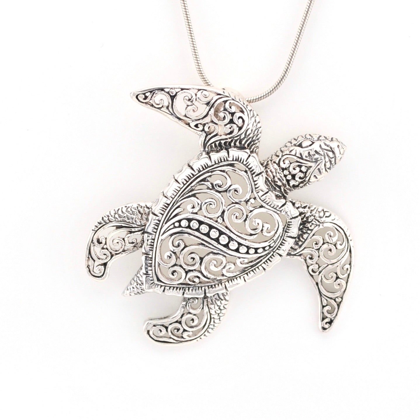Silver turtle pendant necklace on a white background