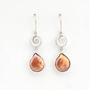 Pair of earrings with teardrop-shaped brown stones on a white background