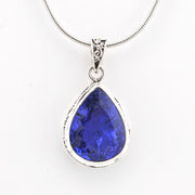 Teardrop-shaped blue gemstone pendant on a white background