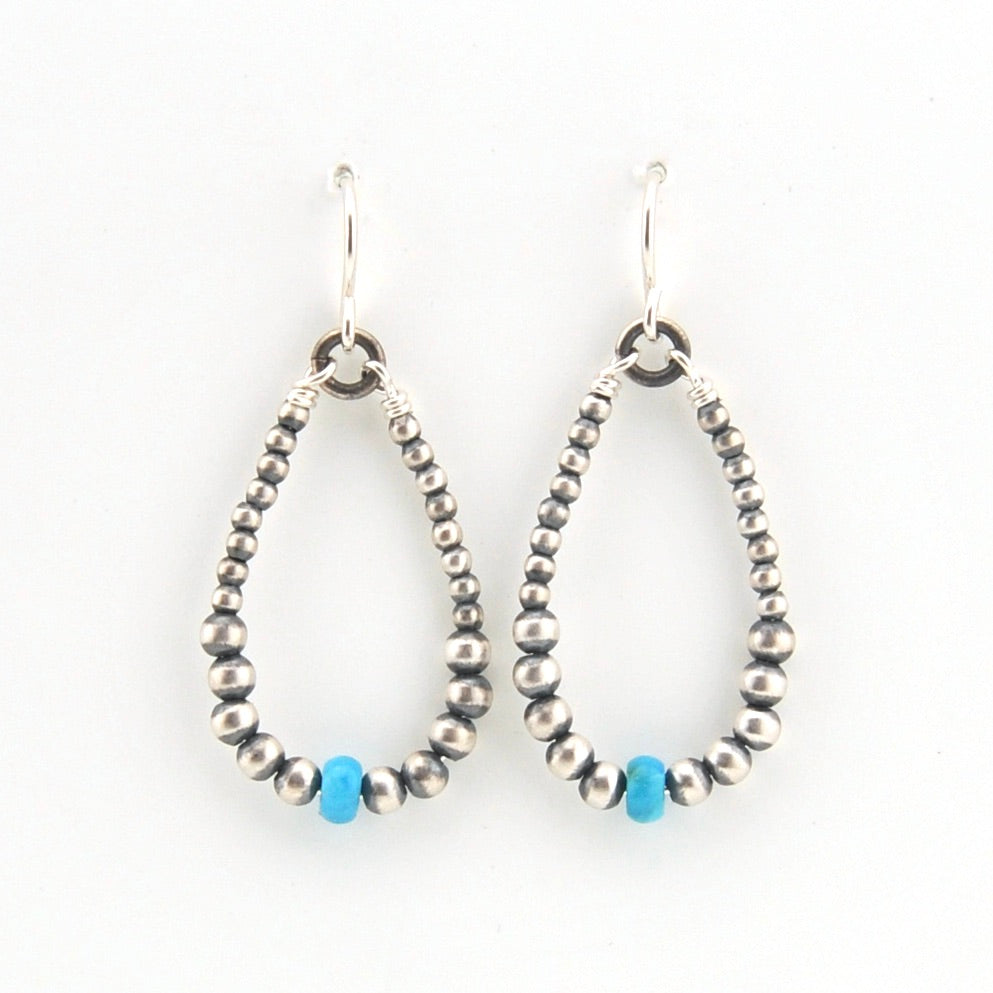 Pair of beaded earrings with turquoise accents on a white background