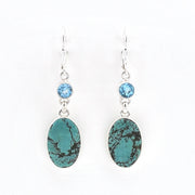 Pair of earrings with turquoise stones and blue gemstones on a white background