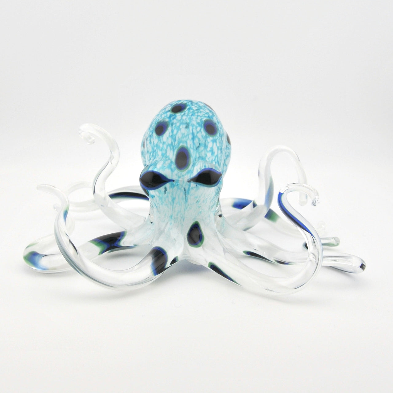 Glass octopus sculpture with blue and white pattern on a white background
