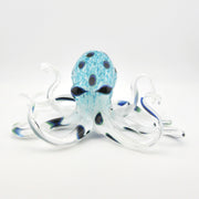 Glass octopus sculpture with blue and white pattern on a white background