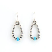 Pair of beaded earrings with blue accents on a white background