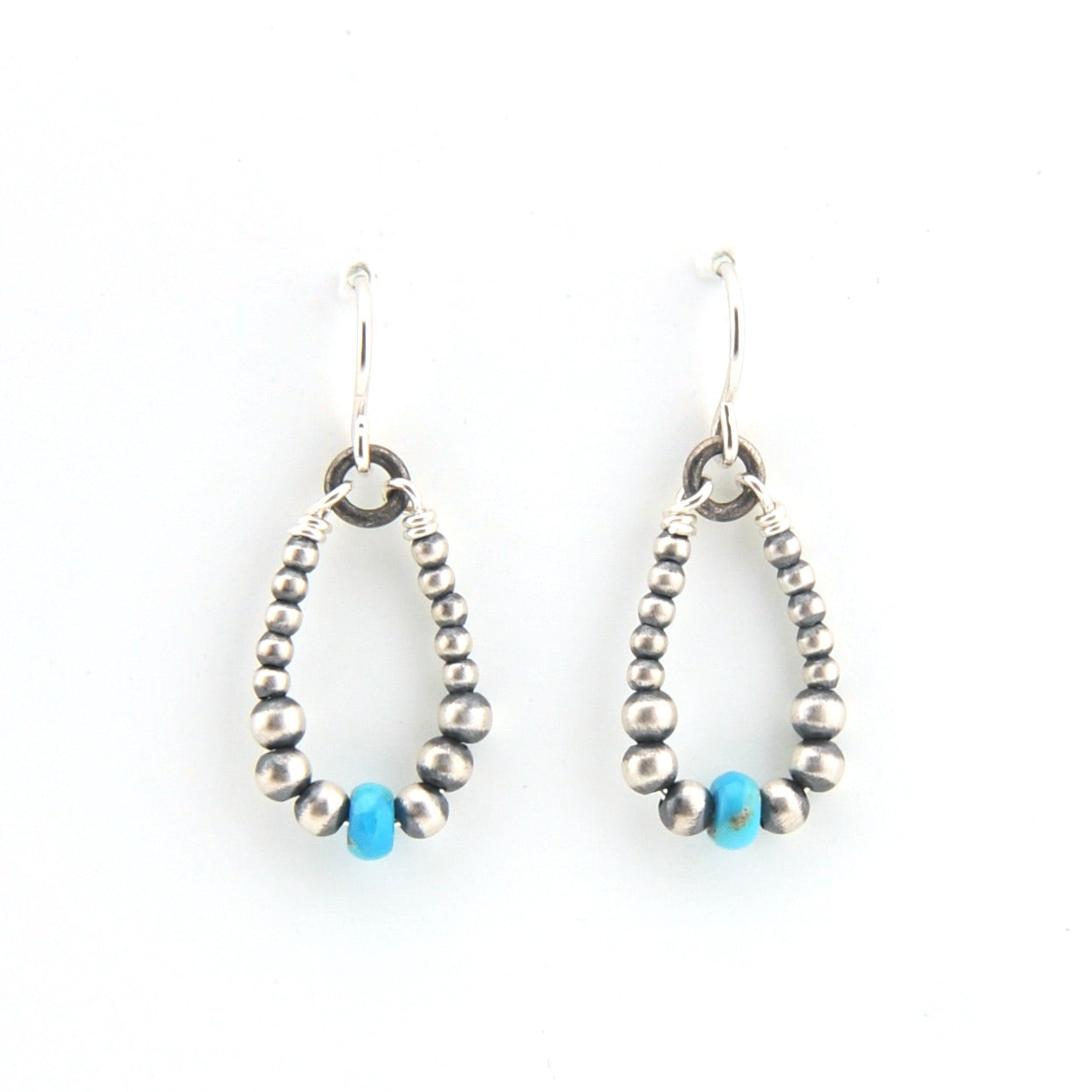 Pair of beaded earrings with blue accents on a white background