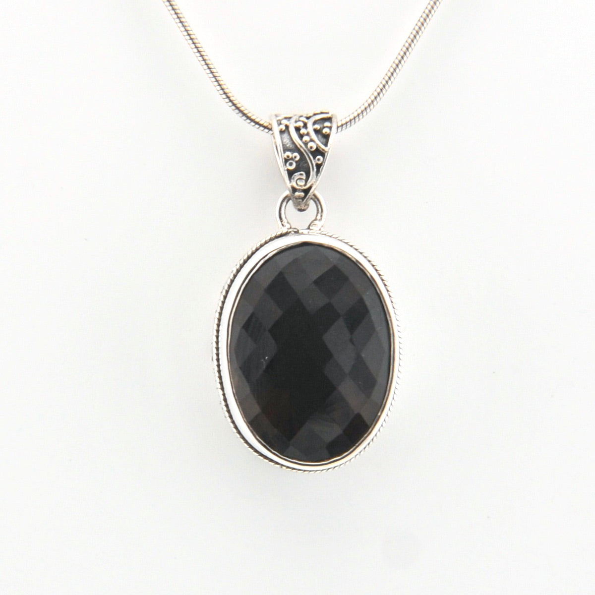 Brown pendant on a silver chain against a white background