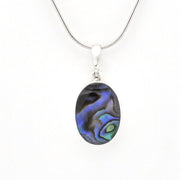 A silver snake chain necklace with an oval pendant featuring a black, blue, and green iridescent abalone shell inlay, shown against a plain white background.