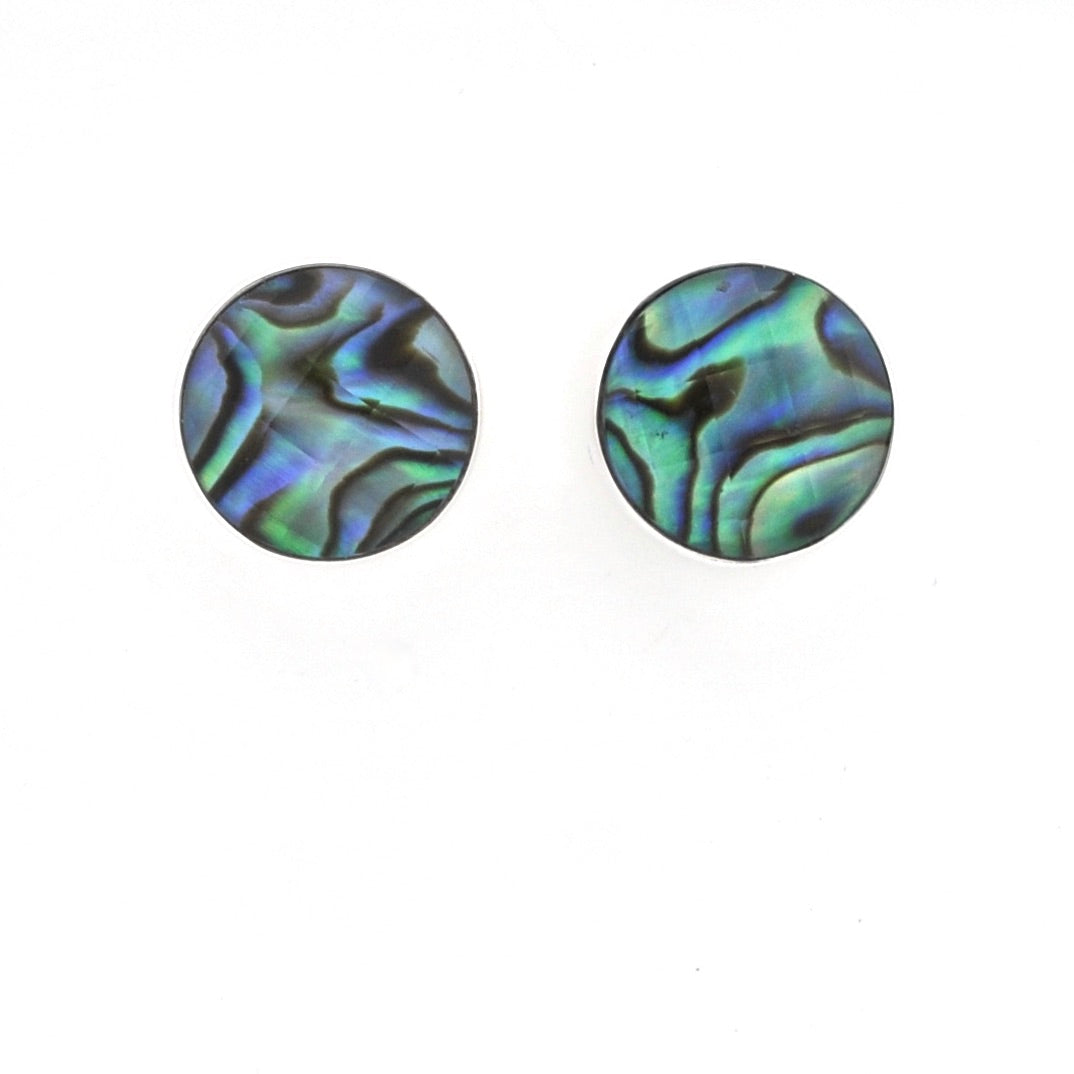 A pair of round stud earrings featuring iridescent abalone shell patterns with swirling shades of green, blue, and black, set against a plain white background.