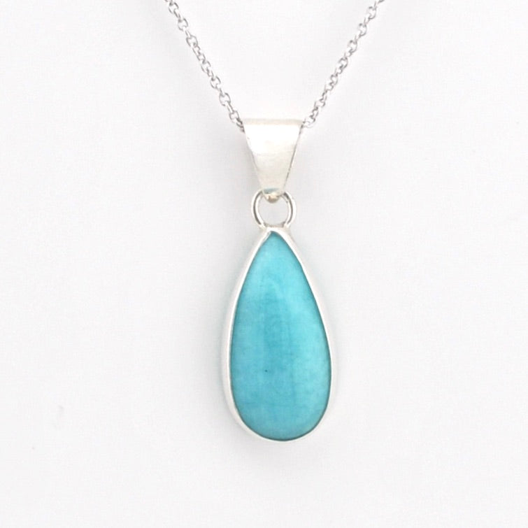 A silver teardrop pendant necklace featuring a smooth, polished light blue stone, suspended from a delicate silver chain against a plain white background.