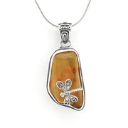A silver dragonfly pendant necklace featuring a polished amber-colored stone in a sterling silver bezel setting, suspended from a silver snake chain against a plain white background.
