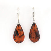 A pair of teardrop-shaped amber drop earrings with silver leverback hooks, displayed against a plain white background.