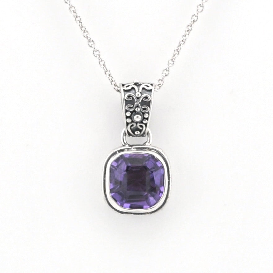 A silver pendant necklace featuring a square-cut purple gemstone in a silver bezel setting, suspended from a delicate silver chain against a plain white background.