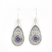 Teardrop-shaped silver earrings with purple gemstones on a white background